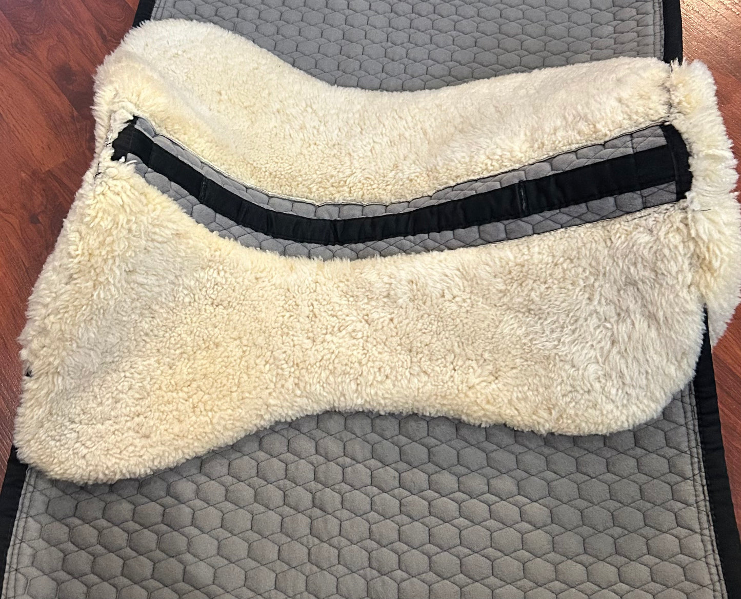 Mattes sheepskin Large black and natural dressage pad. Minor damage to sheepskin.