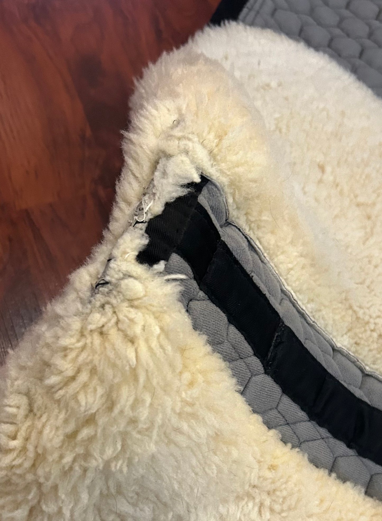 Mattes sheepskin Large black and natural dressage pad. Minor damage to sheepskin.