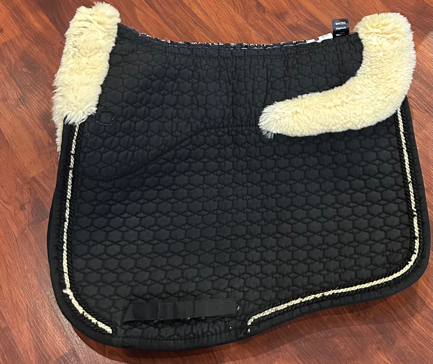 Mattes sheepskin Large black and natural dressage pad. Minor damage to sheepskin.