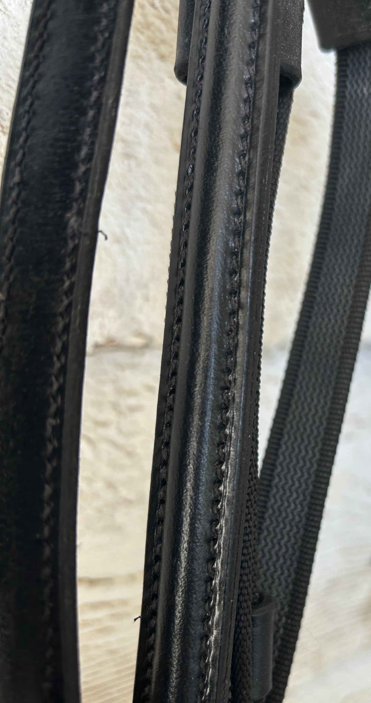 Black raised leather reins. Buckle closure. No slip thin rubber with hand stops