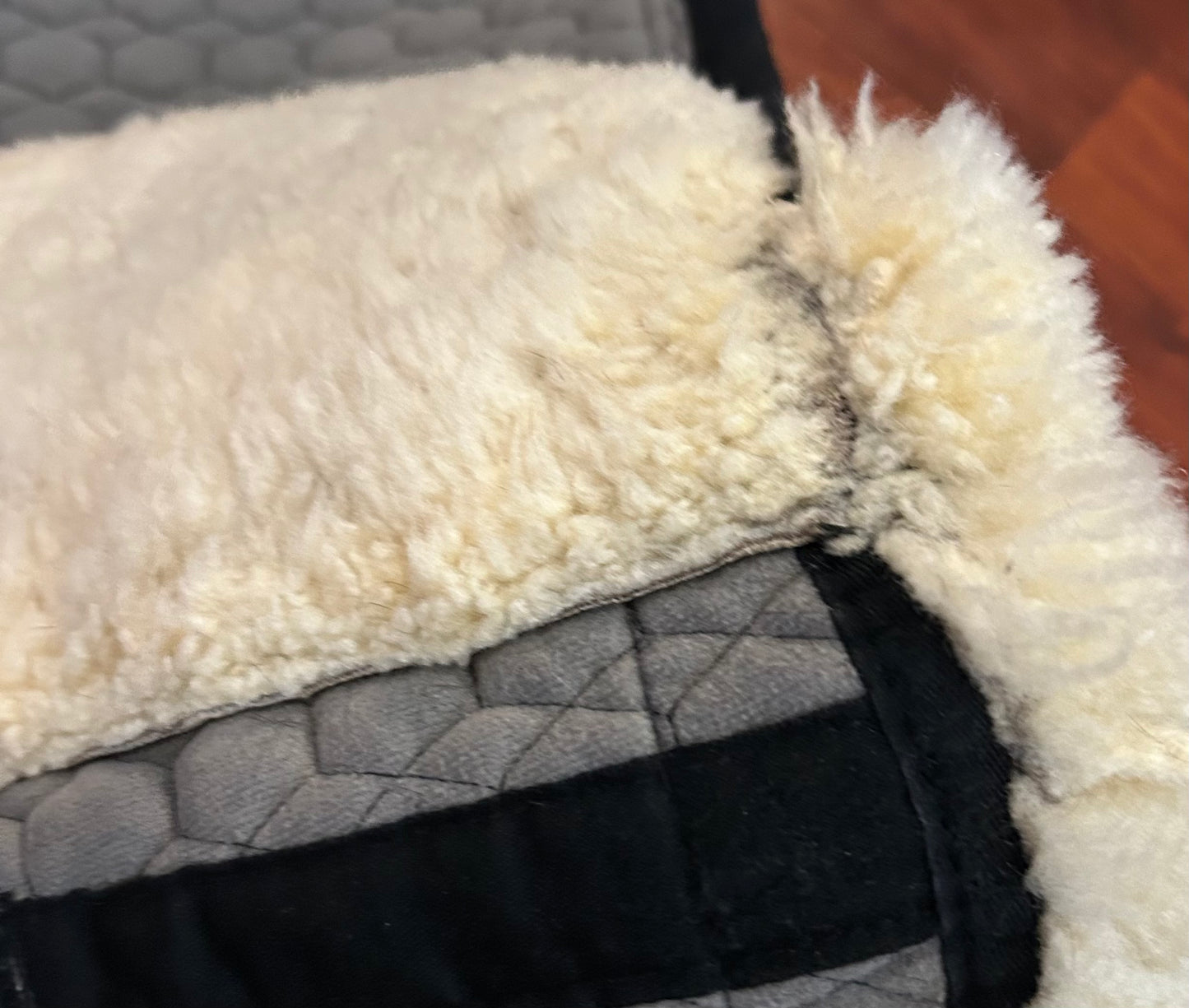 Mattes sheepskin Large black and natural dressage pad. Minor damage to sheepskin.